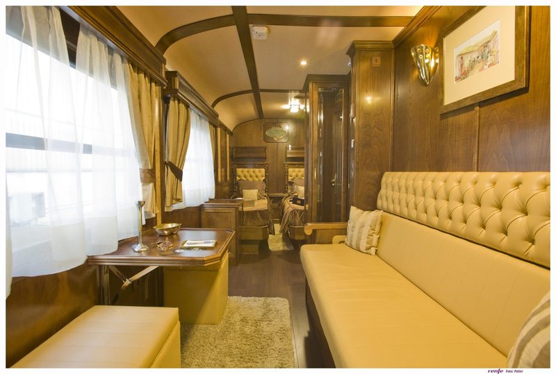 Gran Lujo Deluxe Suite with sofa and desk in front and twin beds at the far end