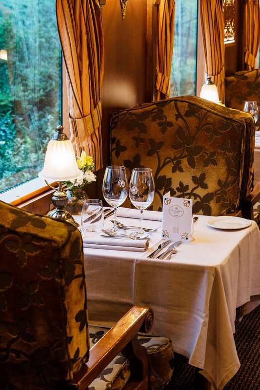 Dining car tables laid for dinner aboard El Transcantábrico