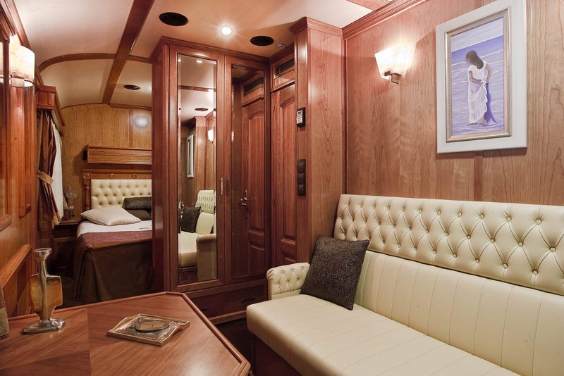 Sitting area of a Gran Lujo Deluxe Suite with sofa, wood panelling and artwork