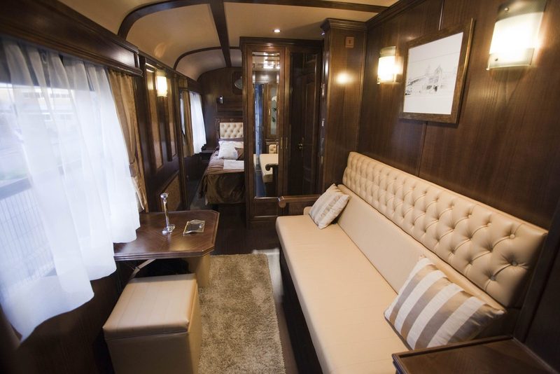 Gran Lujo Deluxe Suite with sofa by the window and the bed beyond