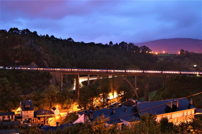 El Transcantábrico crossing a viaduct above Luarca at dusk